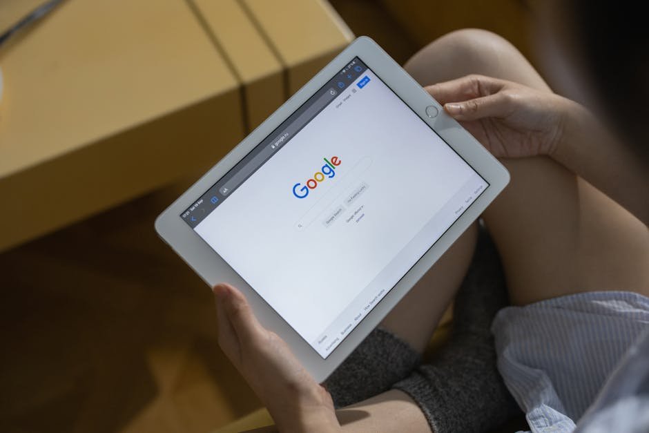 Close-up of hands holding a tablet showing the Google search page. - Google SEO
