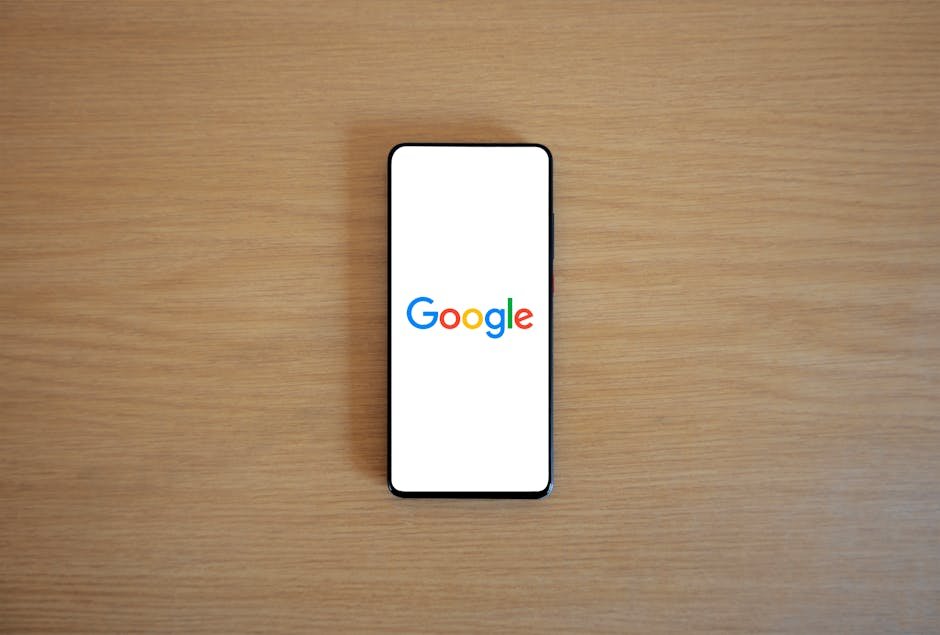 A smartphone displaying the Google homepage on a wooden surface, viewed from above. - google trends